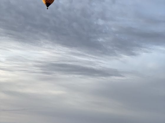A hot air balloon flying away in the sky
