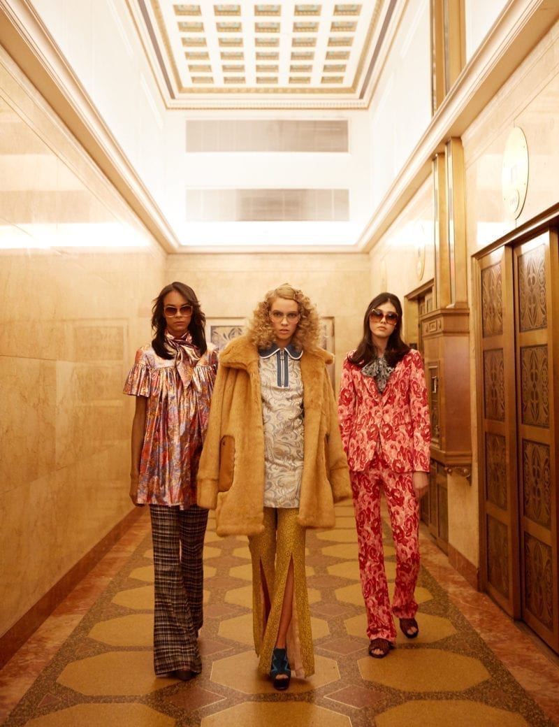 Three women walking down a hallway in 70's high fashion
