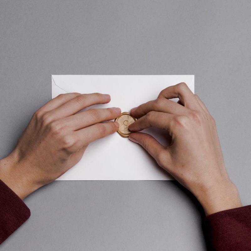 hands touching the seal on an envelope
