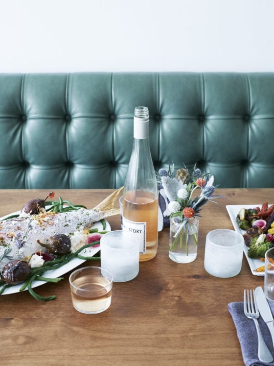 A restaurant table with food and rose