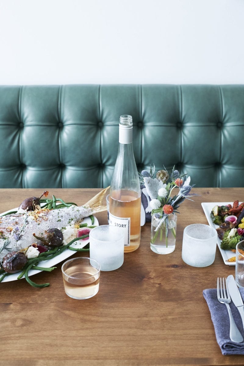 A restaurant table with food and rose