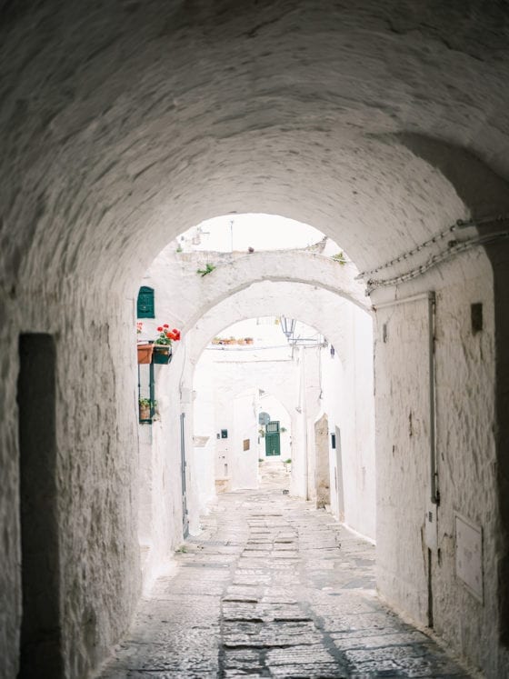A shot of an outdoor tunnel leading to an alleyway in Italy