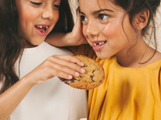 Two girl eating a cookie