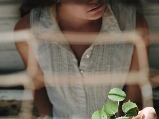 A woman sitting while she looks at greenery