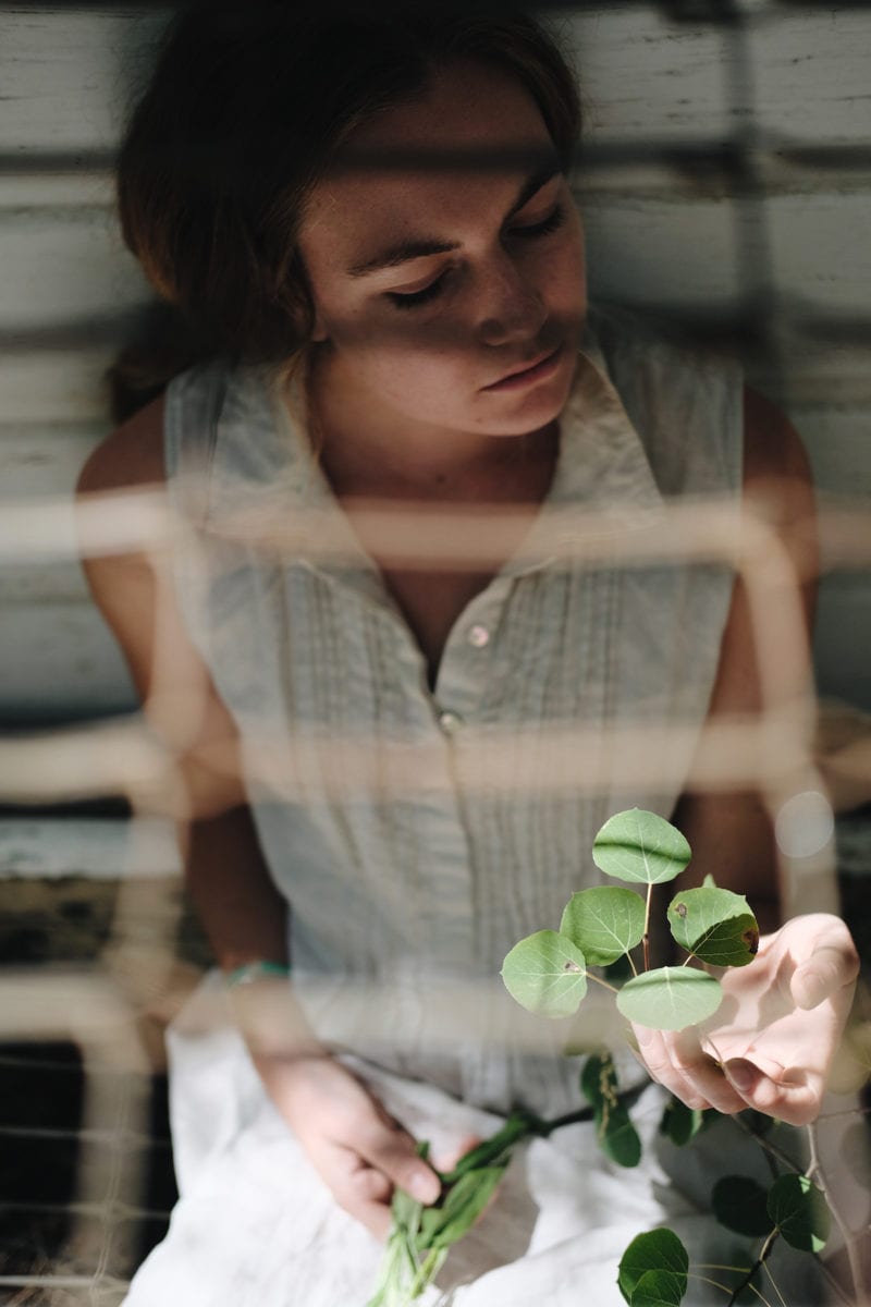 A woman sitting while she looks at greenery