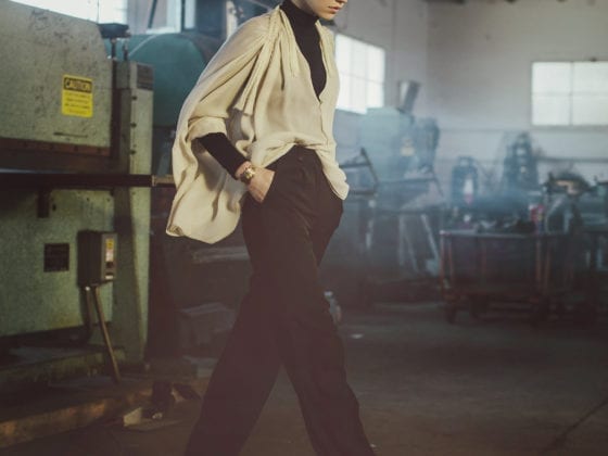 A woman walking in a warehouse looking downward