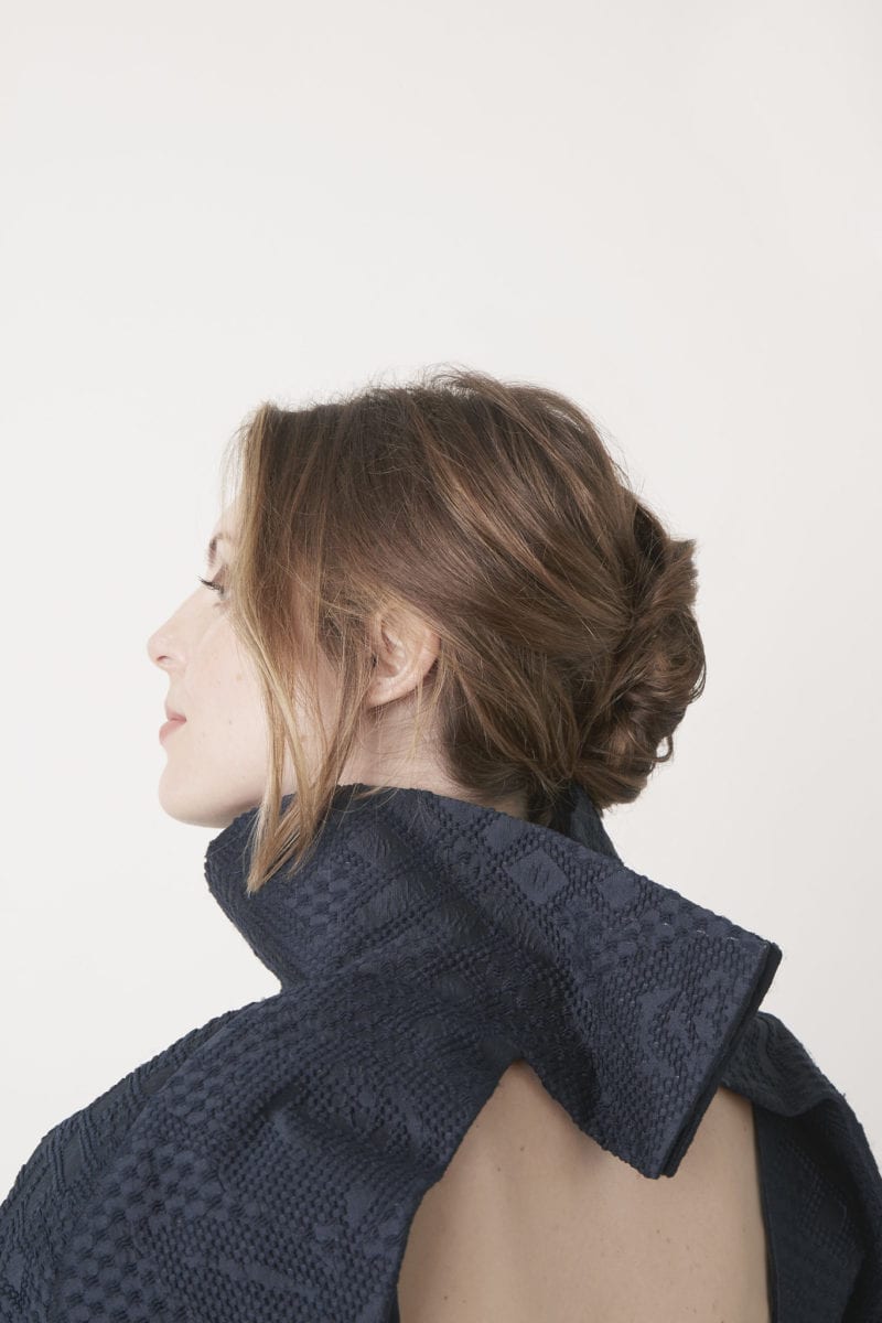 The back of a woman with an open back knit top