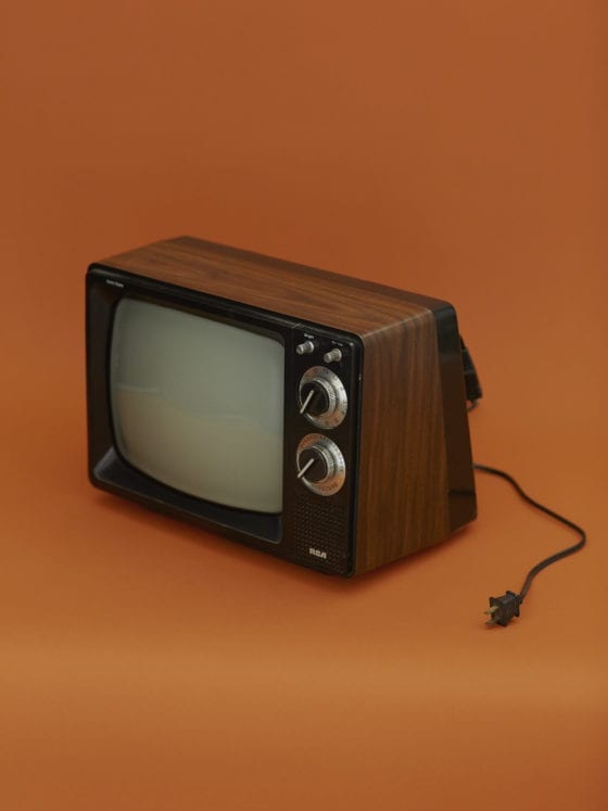 A old TV with the cord stretched out on the table