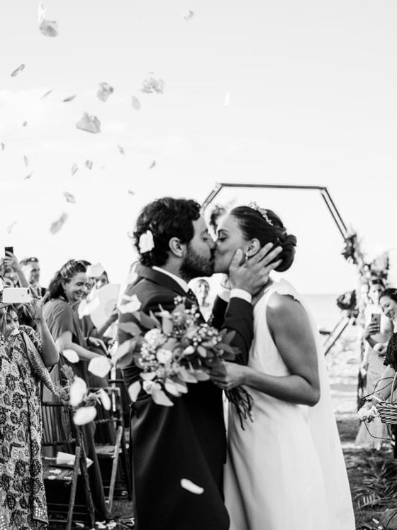 A groom and a bride kissing at their wedding