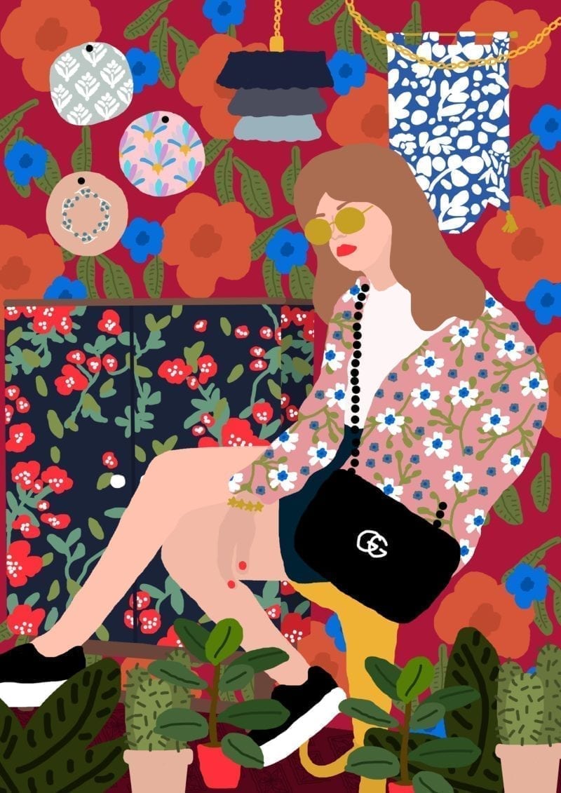 An illustration of a young woman seated on her sofa wearing shades and a designer bag