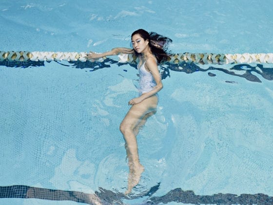 A woman lying on a lane divider in an Olympic pool