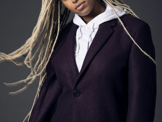 A black woman with long blonde braids blowing in the wind