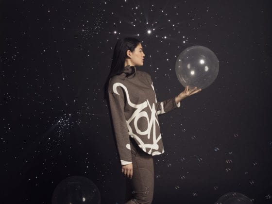 A woman holding a balloon with bubbles surrounding her