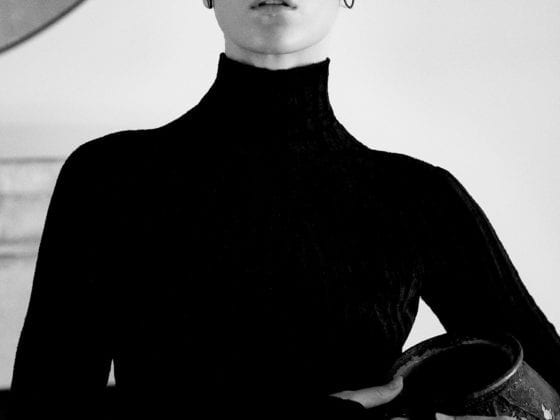 A black and white photo of a woman with her hair slicked back