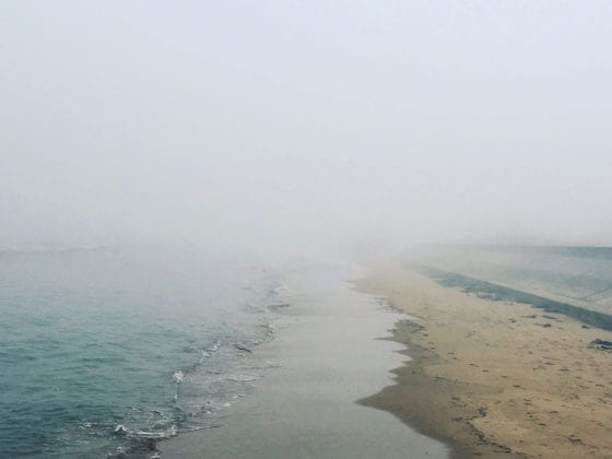 A foggy day at the beach as the waves meet the shore