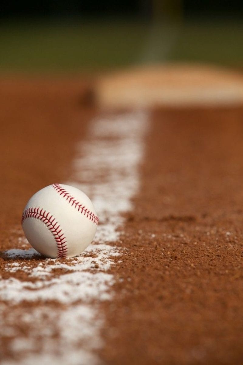 A close up of a baseball on an empty field
