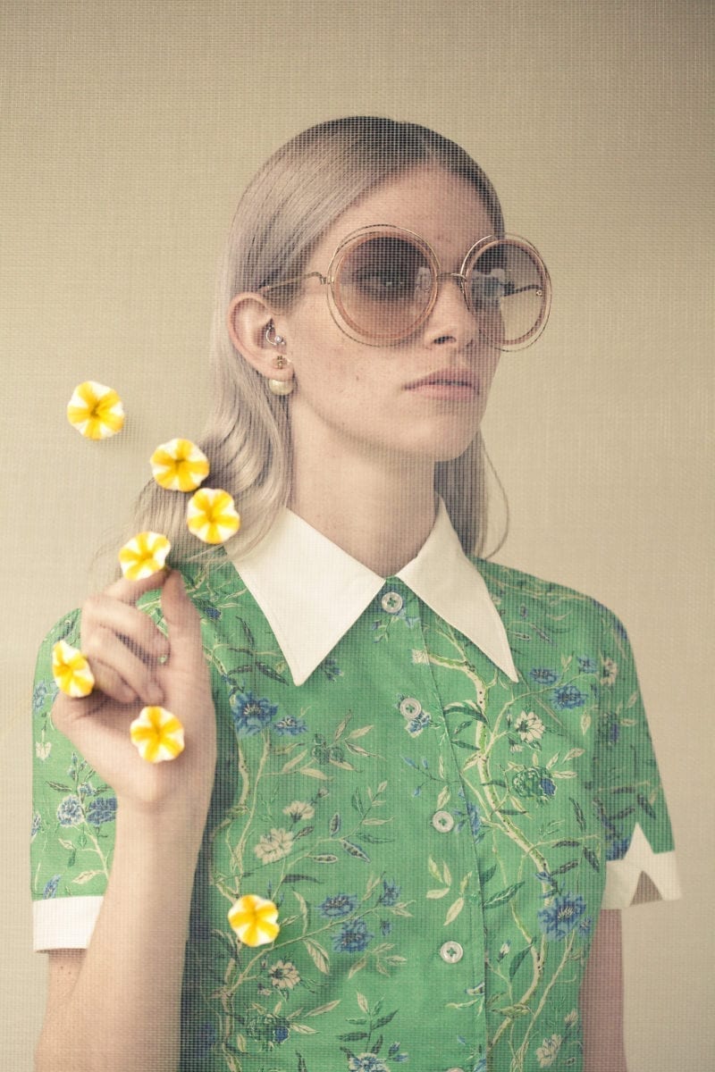 A woman with sunglasses holding flower petals