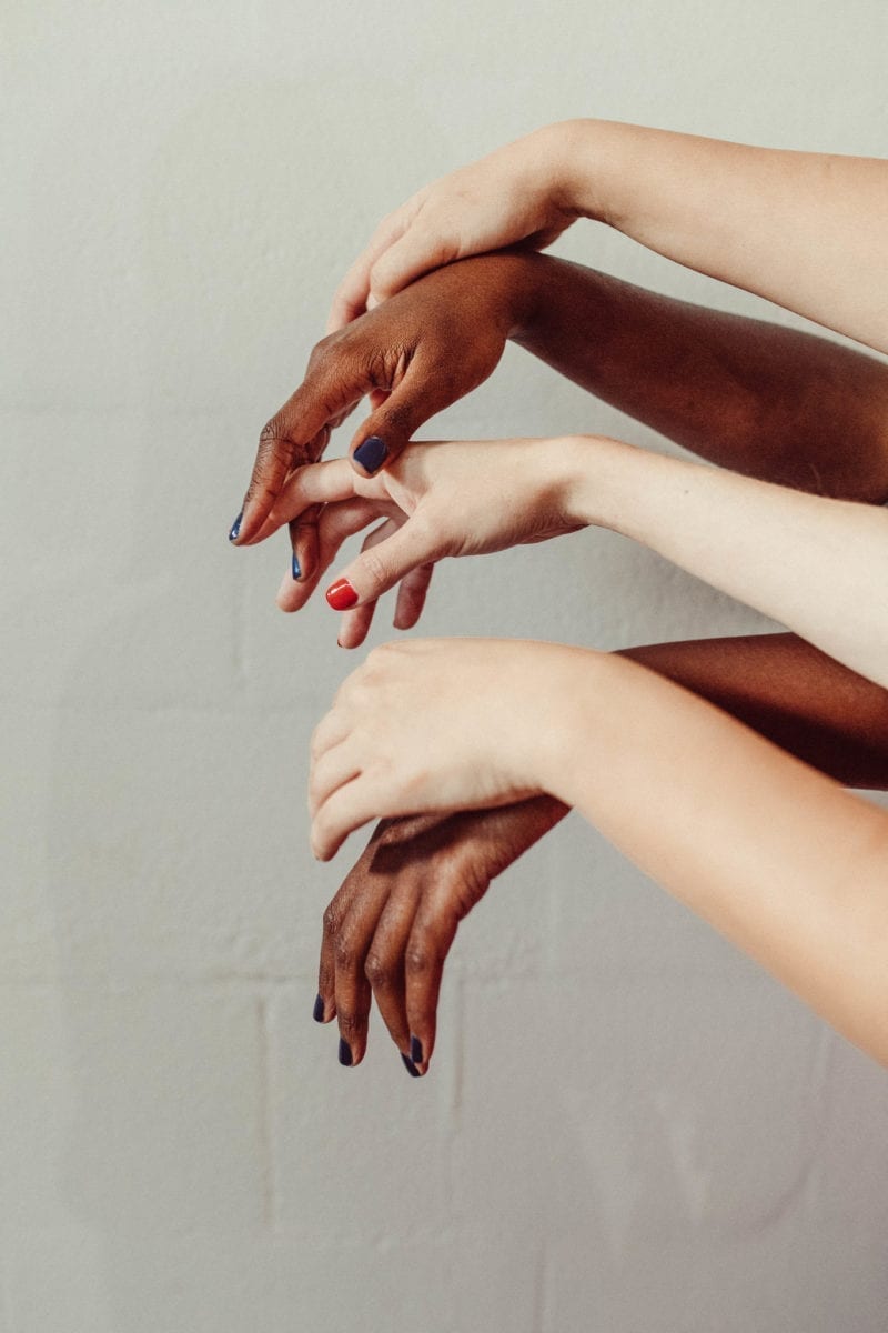 A pair of hands of people of different races intersecting
