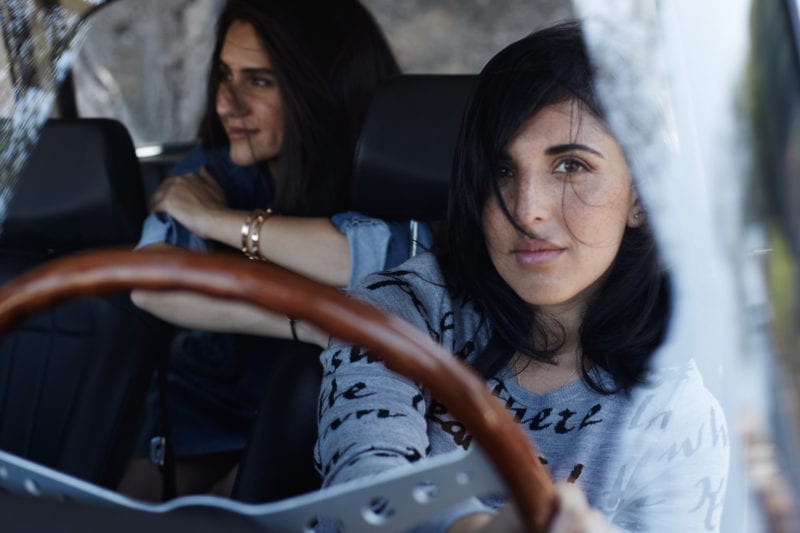 Two women in a car, one in the driver's seat