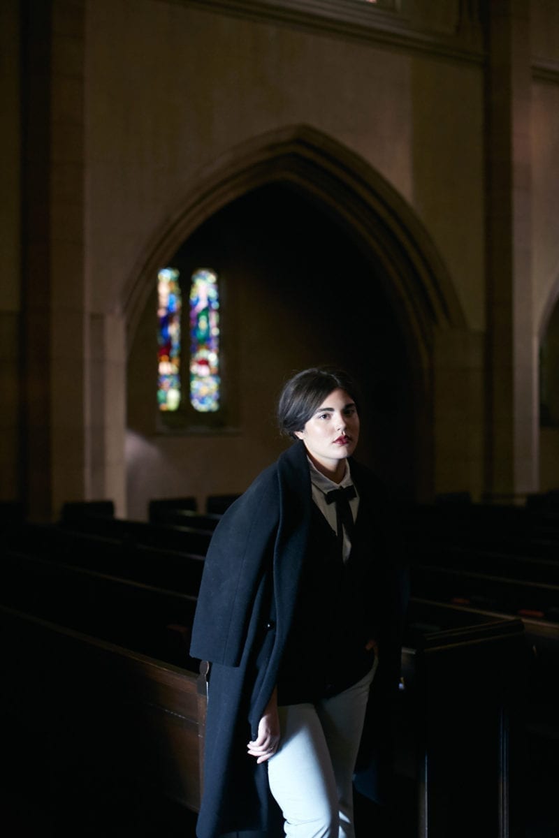 A woman standing inside of a dimly lit chapel